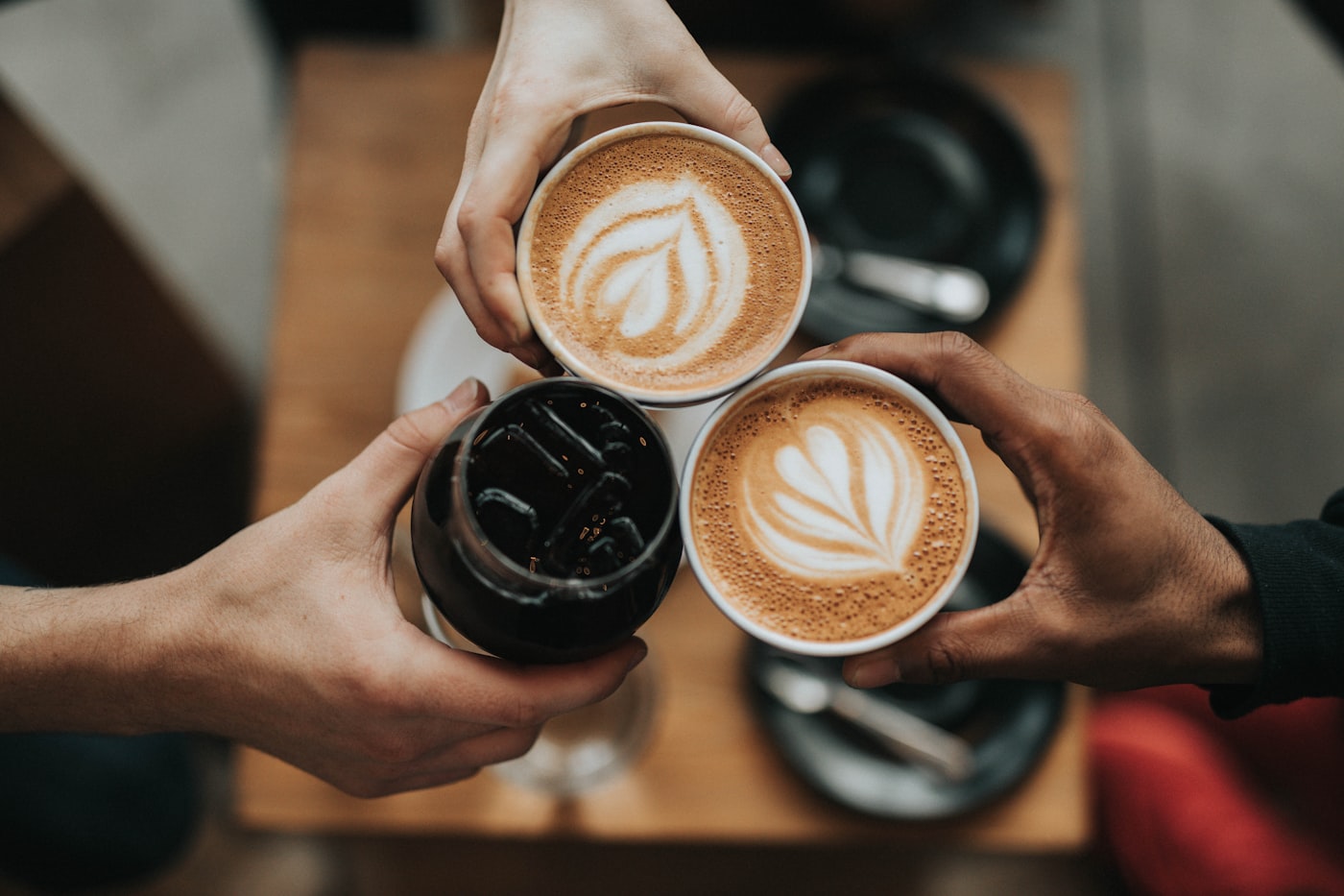 Two coffees raised over a café table