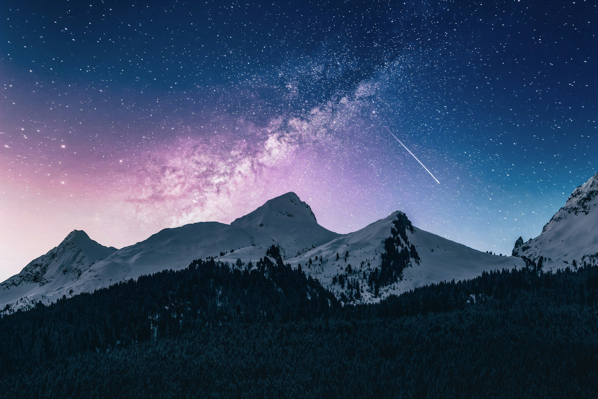 Mountain peaks under a starry night sky