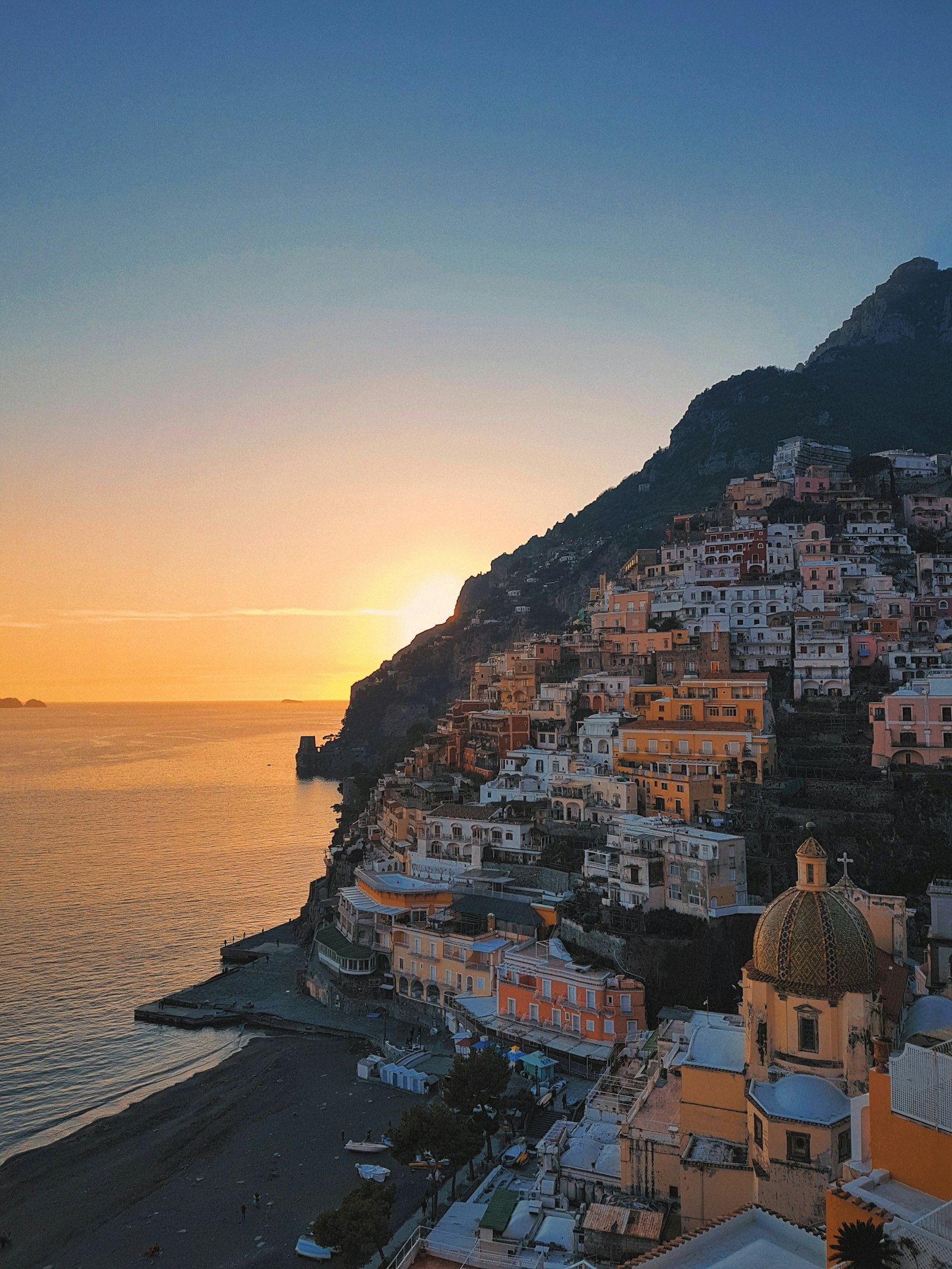 The Amalfi coastline glowing at golden hour, seen from the cliff path